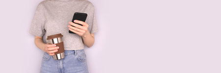 Banner with woman hold in hands coffee cup and use smartphone in front of blue background. selective...
