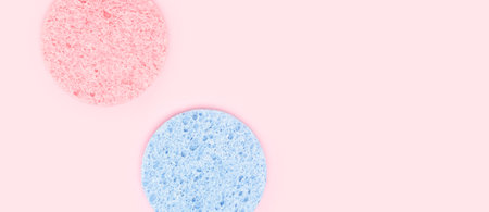 Banner with face wash sponges on a pink background. Place for text.