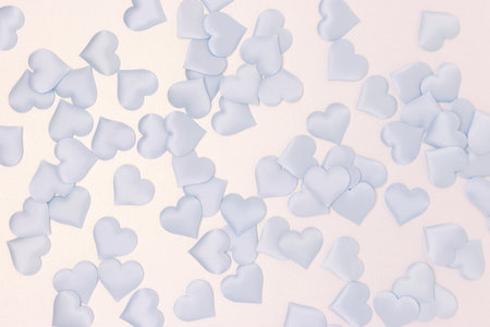 Texture made of blue textile confetti in a heart shape on a silver glittering background.の写真素材