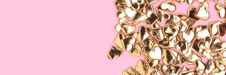 Banner with gold colored hearts confetti on a pink background. Place for your idea.