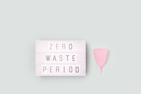 Zero waste period. Lightbox with letters and menstrual cup on a blue background. minimal concept.の写真素材