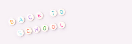 back to school. Banner with quote made of beads with letters on a blue background.