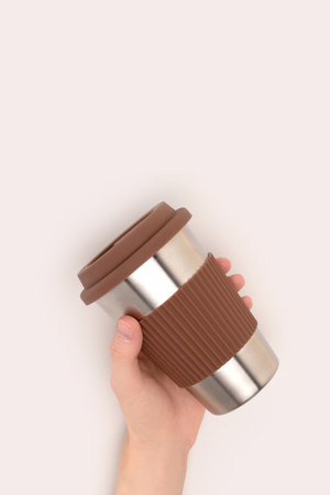 Hand hold reusable coffee cup on a gray background. Zero waste concept with copy space.の写真素材