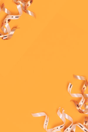 Golden ribbons scattered on a yellow background with copy space. selective focus.の写真素材