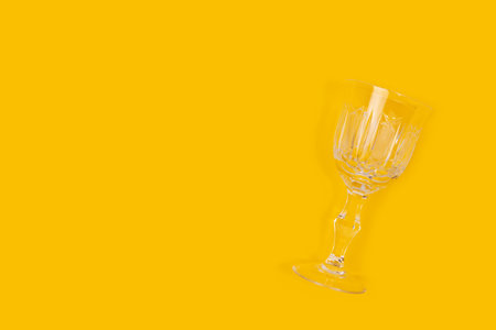 Vintage crystal glass on a yellow background. Minimal composition with copy space.の写真素材