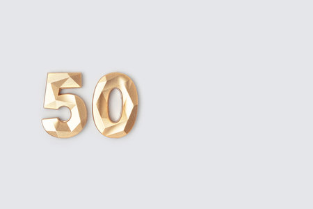 golden number fifty on a blue background. minimal concept.の写真素材
