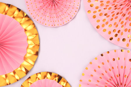 Border frame made of pink paper fans on a blue background. Festive concept with copy space.の写真素材