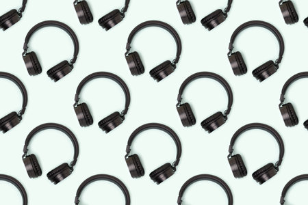 Repetitive pattern made of wireless headphones on a blue pastel background.の写真素材