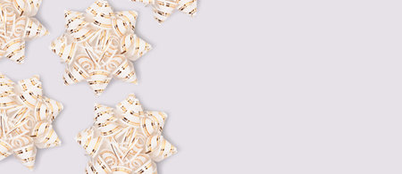 Banner with gold colored ribbon bows scattered on a blue background. Festive concept with copy space.の写真素材