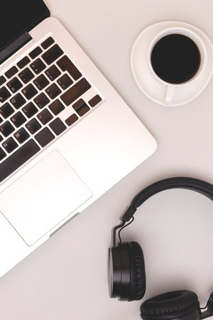 Headphones, cup of black coffee and laptop on a gray background. e-learning concept.の写真素材