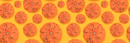Banner with pattern made of orange pumpkins on a yellow background.の写真素材