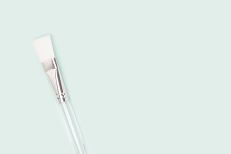Makeup brush with transparent handle on a blue background.の写真素材