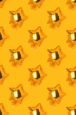 Pattern made of golden inflatable balloons in a star shape on a yellow background.