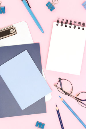 Blue colored school supplies on a pink background. Empty notepad.