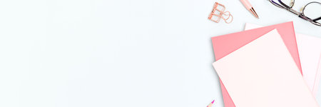 Banner with pink colored school supplies on a blue background.