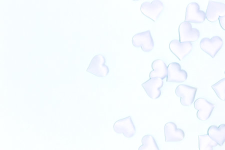 Textile hearts confetti scattered on a blue pastel background. Monochrome composition with copy space.の写真素材