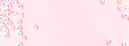 Banner with frame made of beads with letters on a pink background. Creative concept with copy space.