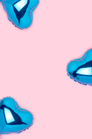 Frame made of blue foil balloons in a heart shape on a pink background. Creative composition.の写真素材