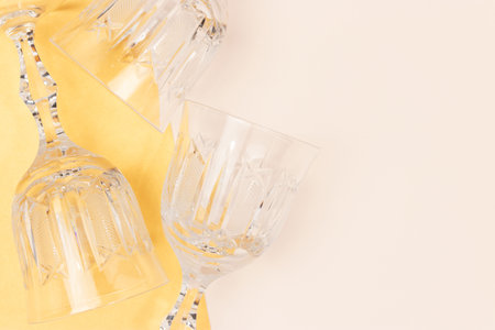 Vintage crystal glasses on a beige and gold background. Place for text.の写真素材