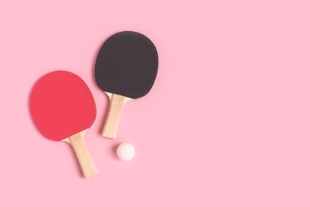 Table Tennis rackets and white ball on a pink pastel background. Place for text.の写真素材