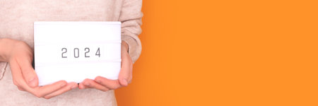 Banner with 2024 numbers in front of yellow background. New Year creative concept with copy space.の写真素材