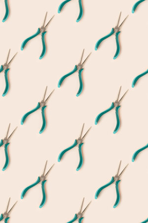 Pattern made of needle-nose pliers on a beige background.の写真素材
