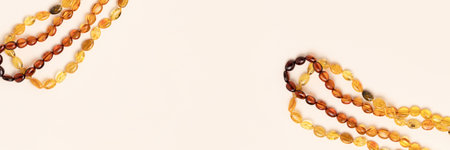 Banner with amber beads on a beige background. Copy space for text.の写真素材