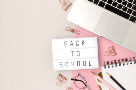 Back to school. Workspace with lightbox, laptop and office supplies on a gray and pink background. Online education concept with place for text.の写真素材