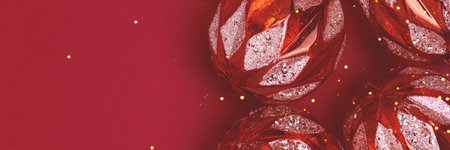 Banner with golden glittering Christmas toys on a red background. Festive concept with place for...