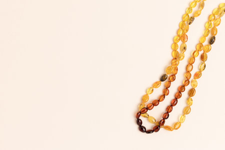 Amber beads laid on a beige background. Composition with copy space.の写真素材