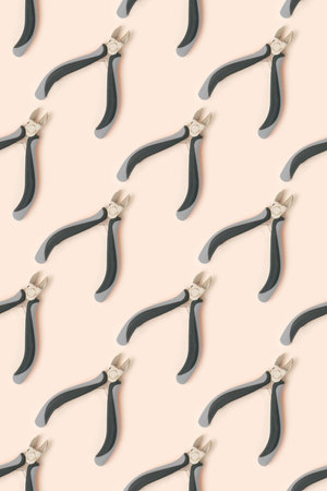 Pattern made of wire cutters on a beige background.の写真素材