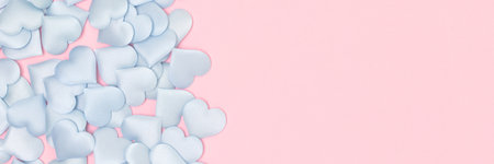 Banner with blue hearts confetti on a pink background. Place for text.