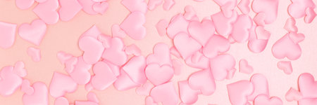 Banner with texture made of pink confetti in a heart shape on a glittering background.