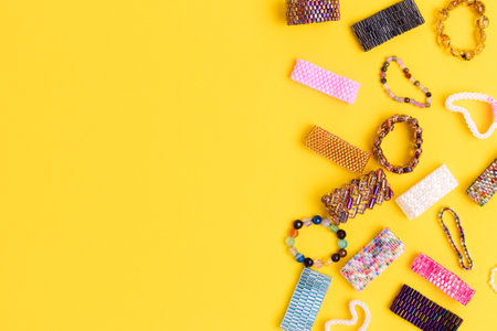 Multicolored handmade beaded rings on a yellow background. Place for text.の写真素材