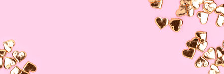 Banner with gold colored hearts confetti scattered on a pink background.の写真素材