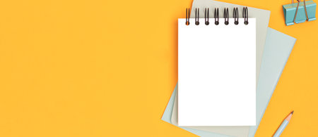 Banner with clean notepad mockup and stationery on a yellow background.の写真素材