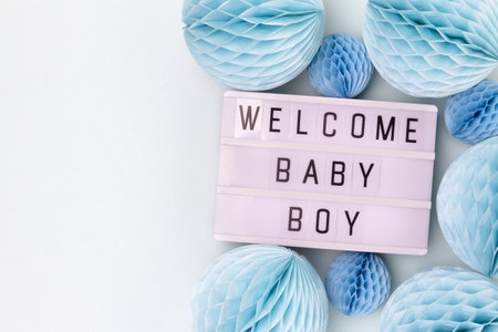 Welcome baby boy. Lightbox with letters and tissue paper balls in a blue color. Festive concept with place for text.の写真素材