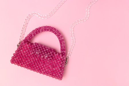 Handmade beaded bag with transparent chain on a pink background. Place for text.の写真素材