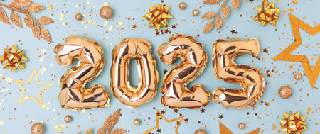 2025 New Year festive banner. Golden air balloons and decorations on a blue background.の写真素材