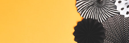 Banner with black and white paper fans on a golden glittering background with copy space.