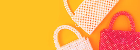 Banner with handmade bags made from acrylic beads on a yellow background.の写真素材