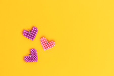 Hearts made of beads on a yellow background. Place for text.の写真素材