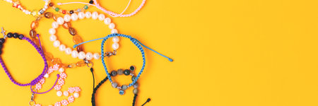 Banner with handmade bracelets made of beads and cords on a yellow background.の写真素材