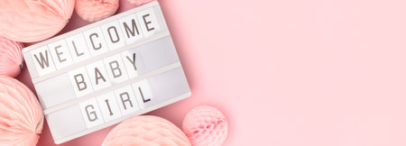 Welcome baby girl. Banner with lightbox and tissue paper balls in a pink color.の写真素材