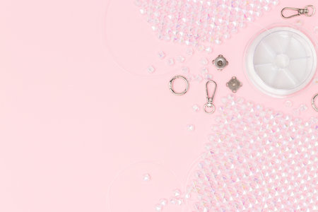 Details, equipment and findings for handmade beaded bag scattered on a pink background with place for text.の写真素材