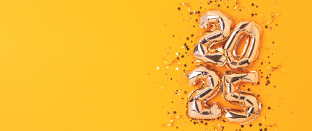 2025 New Year banner. Golden numbers inflatable balloons, ribbons and shiny stars confetti on a...