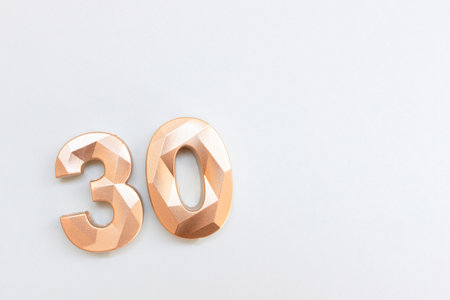 Golden number thirty on a blue background.の写真素材