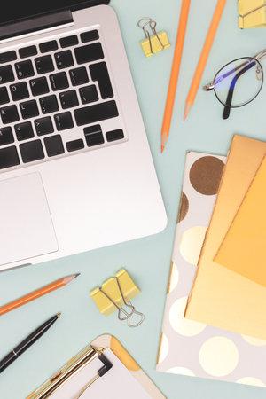 Stationery and laptop on a blue background. Workspace for e-learning.