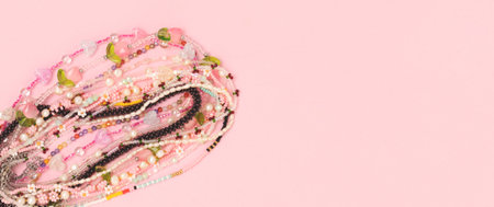 Banner with various handcrafted beads on a pink background.の写真素材