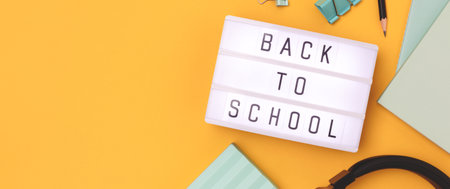 Back to school. Banner with lightbox and stationery on a yellow background.